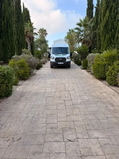 A van at the end of a cypress drive
